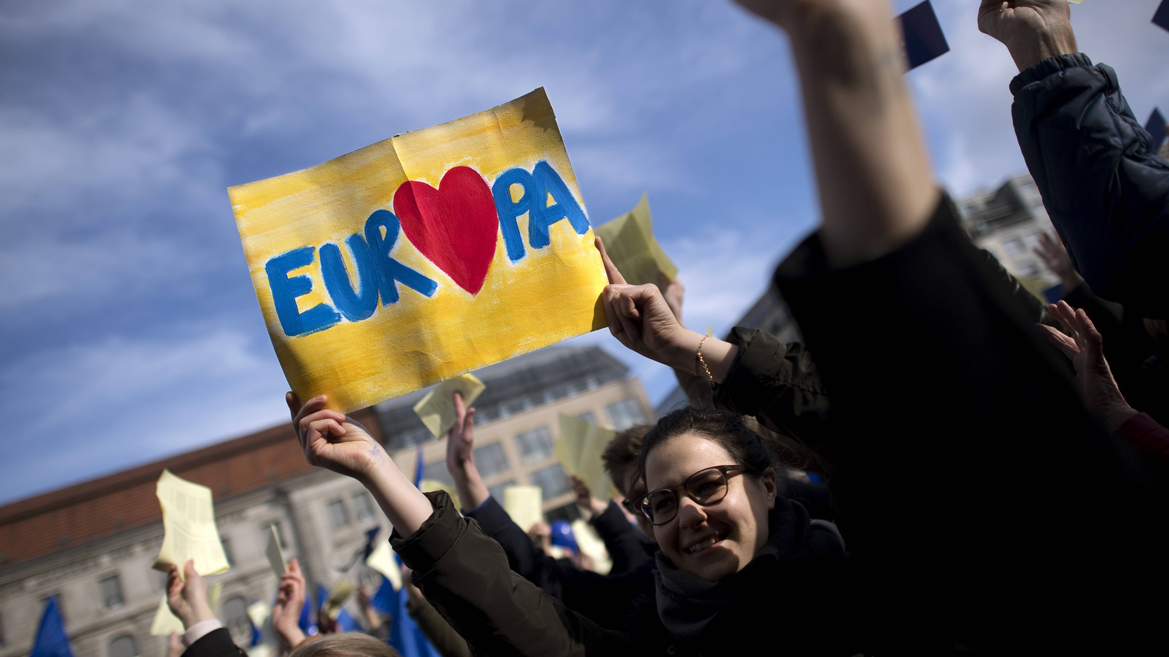 Eine Frau hält ein Schild hoch mit einem Herz für Europa.